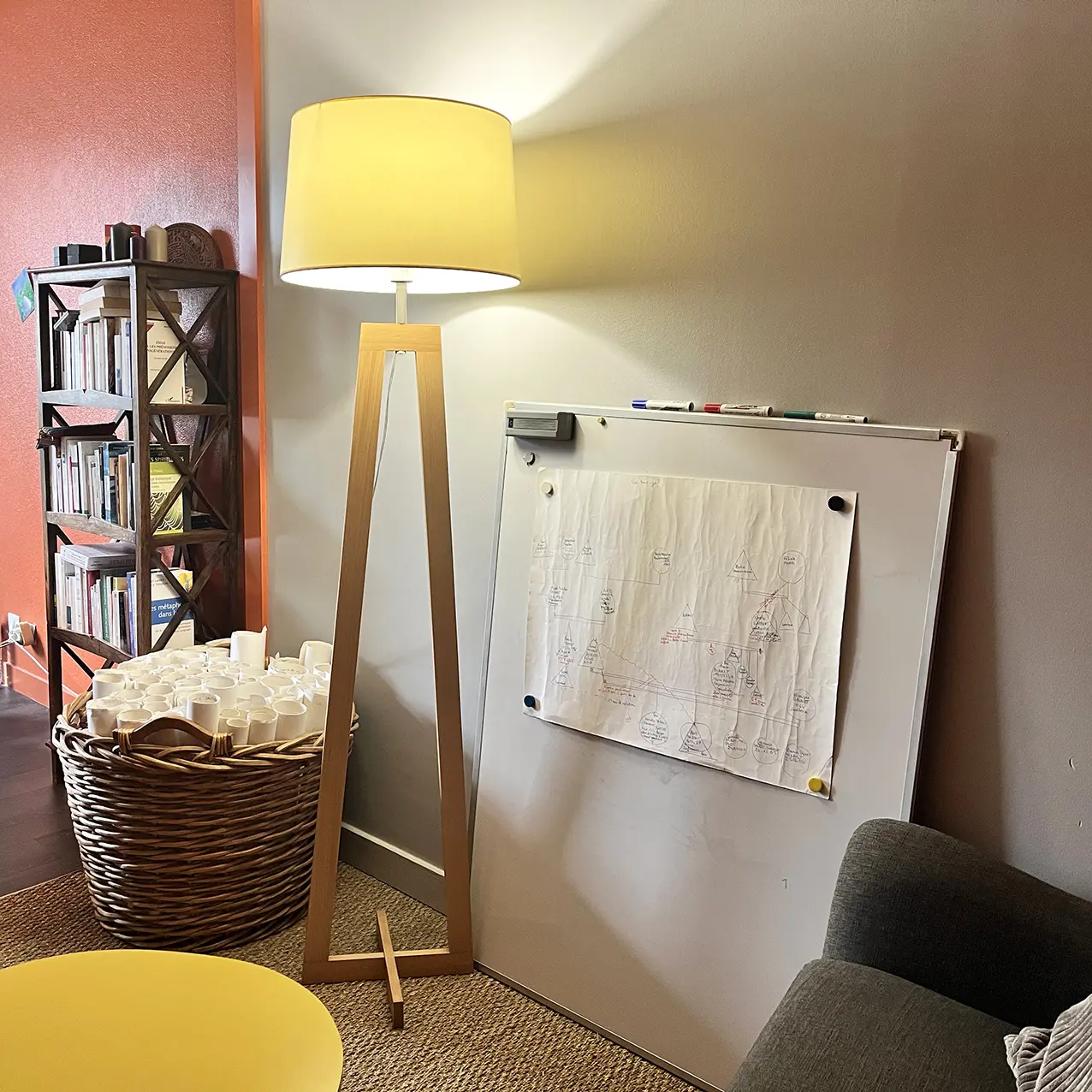 Cabinet de Elisabeth Julien, ou l'on voit un tableau blanc ainsi qu'une lampe. Zone ou les clients travaillent leur arbre.